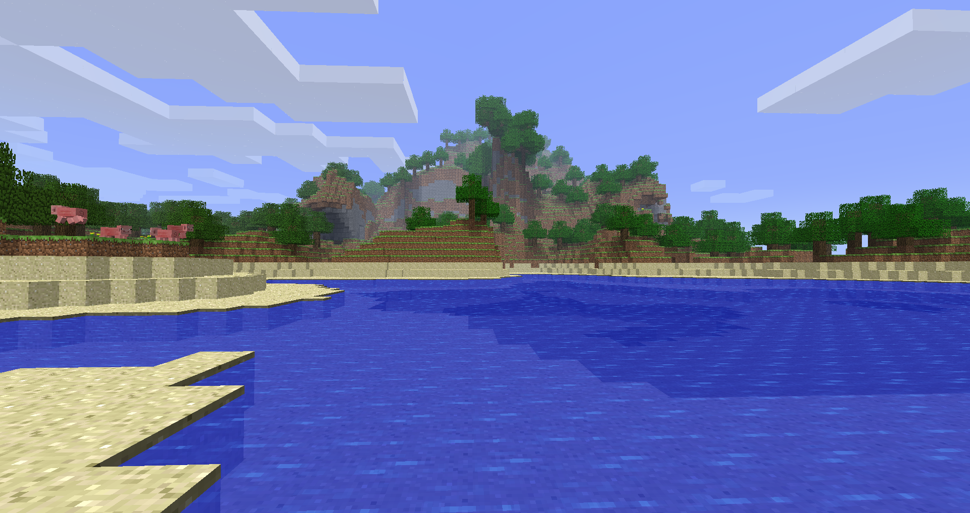 A sandy riverbank surrounded by grassy hills and trees in Minecraft Alpha Continued.